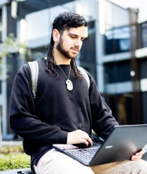 Student studying on laptop outside
